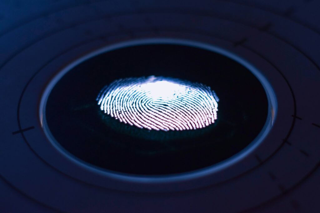 Close-up of a glowing fingerprint on a digital scanner.