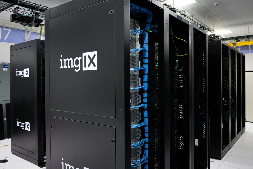 Modern data center with black server racks labeled imgIX and organized blue network cables for cloud computing infrastructure