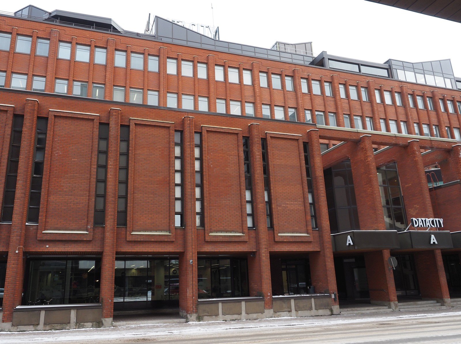Exterior view of DataCity building in Turku, Finland, featuring red brick architecture and multiple office floors